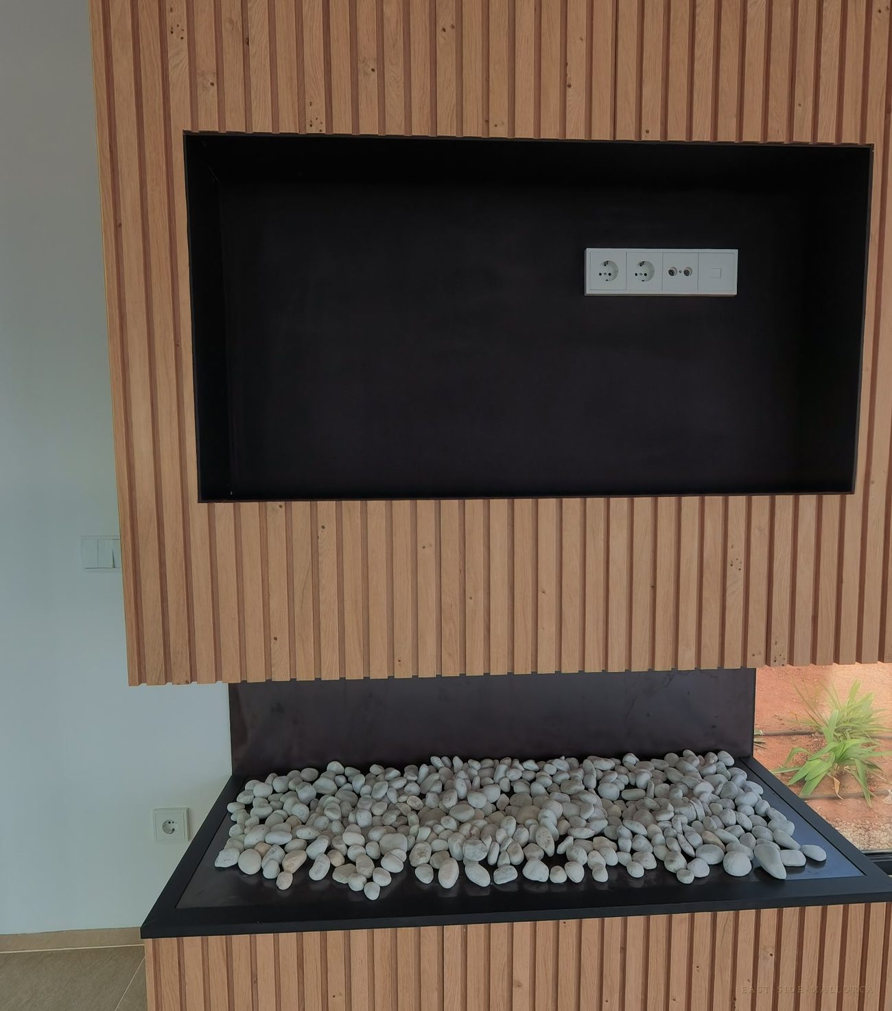 Kamin vor einer Wand aus Holzlamellen