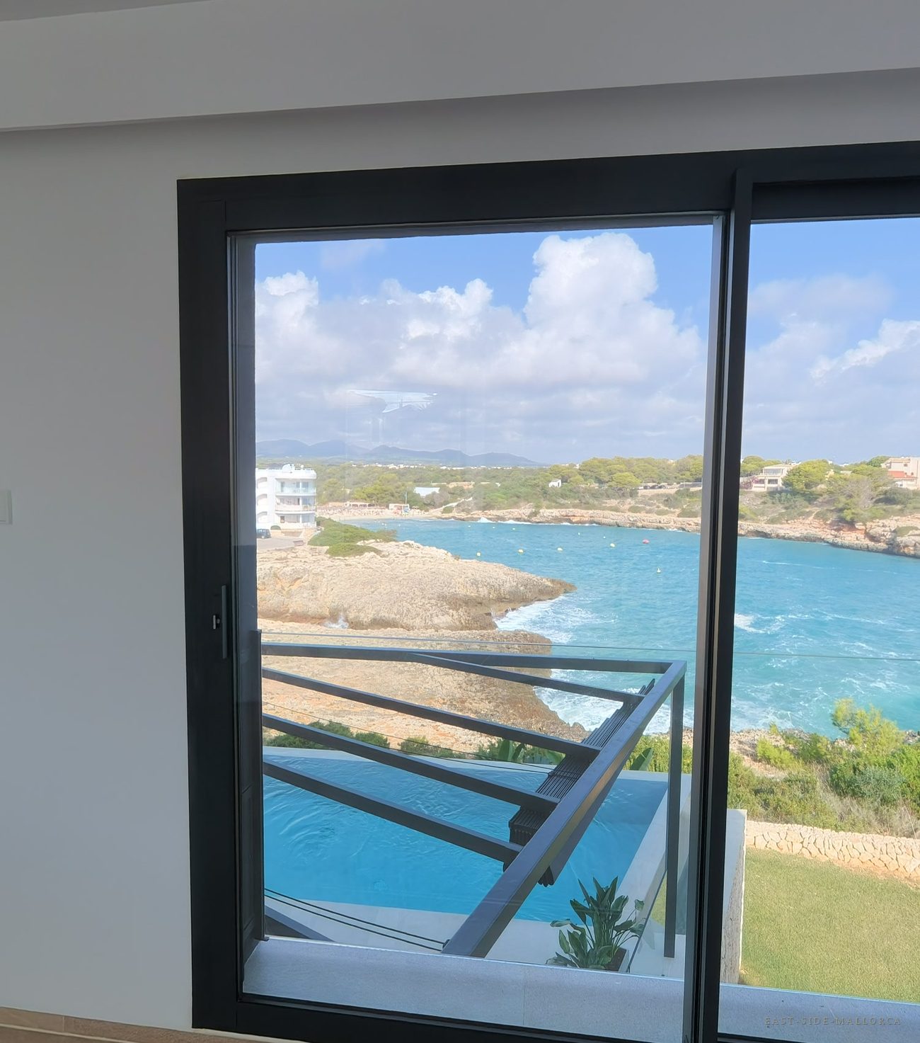 Master-Suite mit bodentiefem Fenster zur Bucht