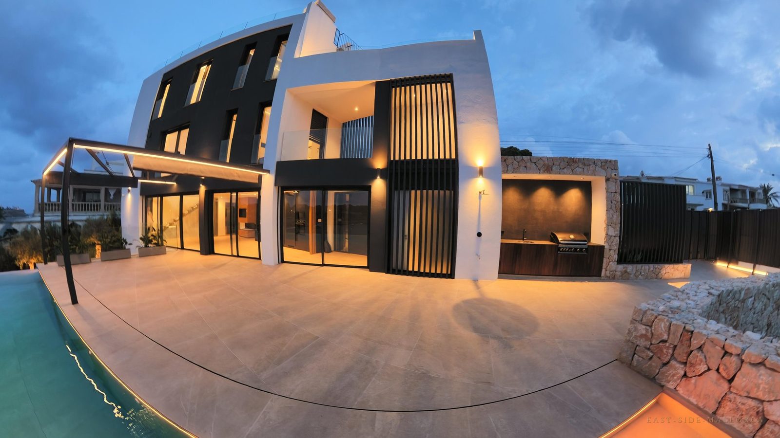 Beleuchtete Poolterrasse der Villa am Abend