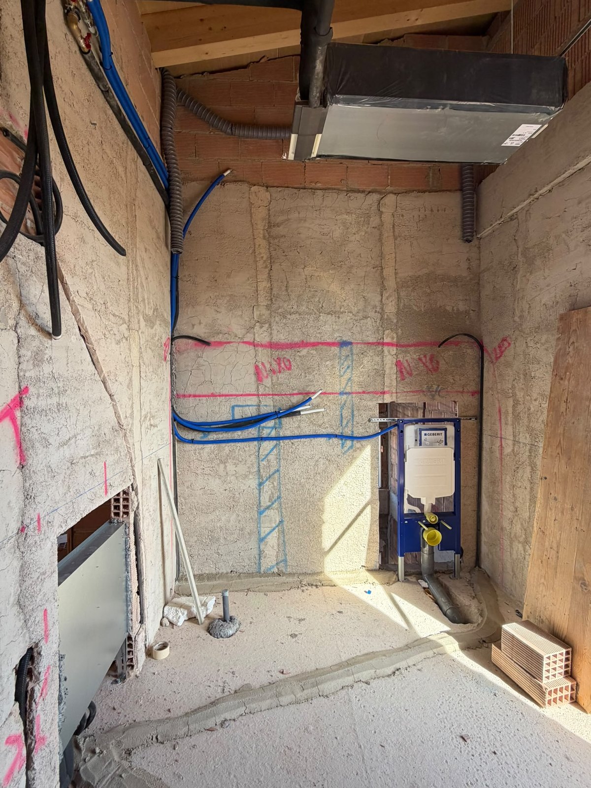 Bad in Rohinstallation mit Vorwandelement, Wasserleitungen und Lüftungskanal